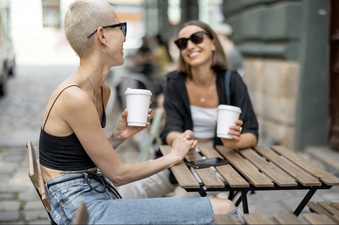 Two women chatting over coffee outdoors