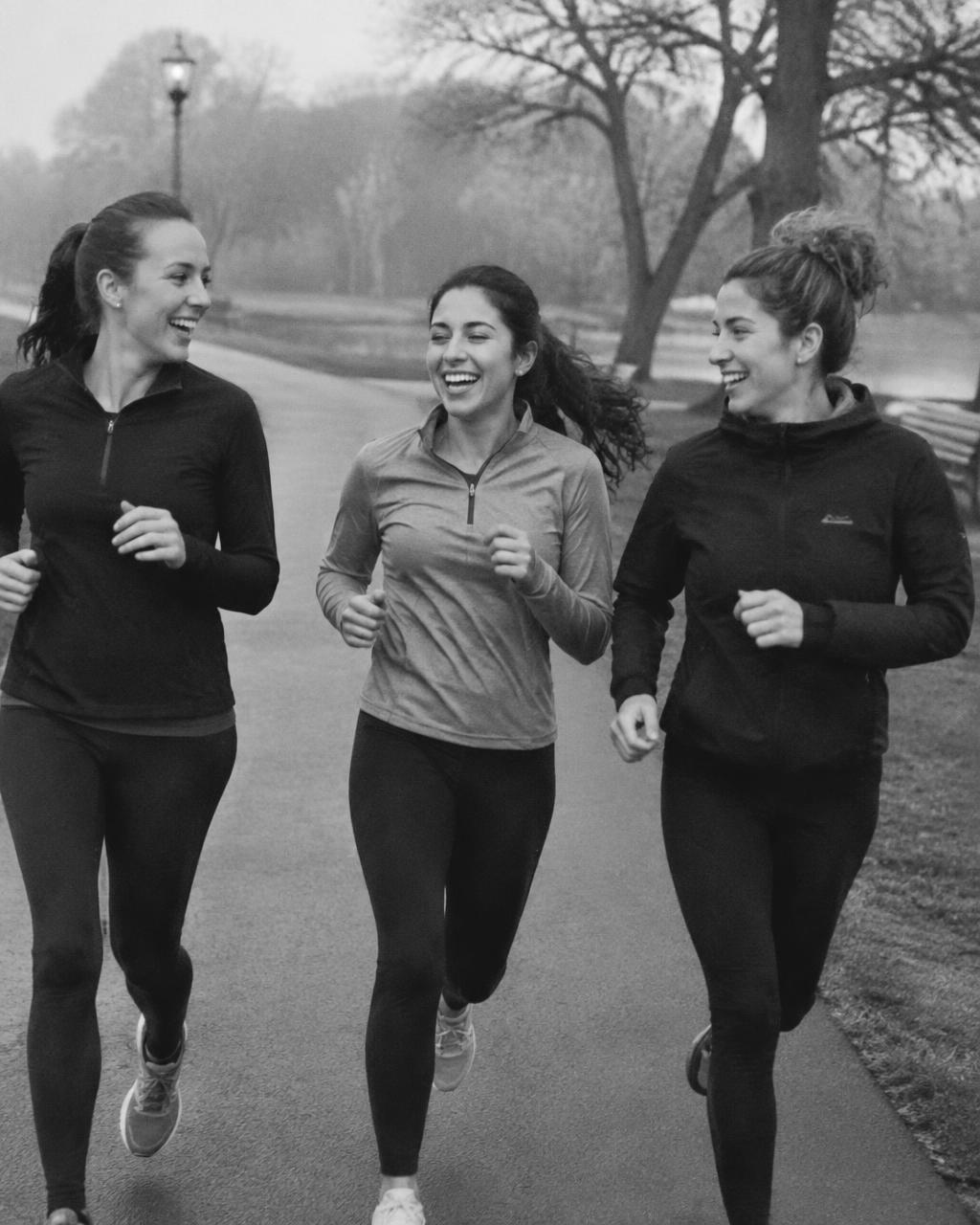 Three friends running together in a park
